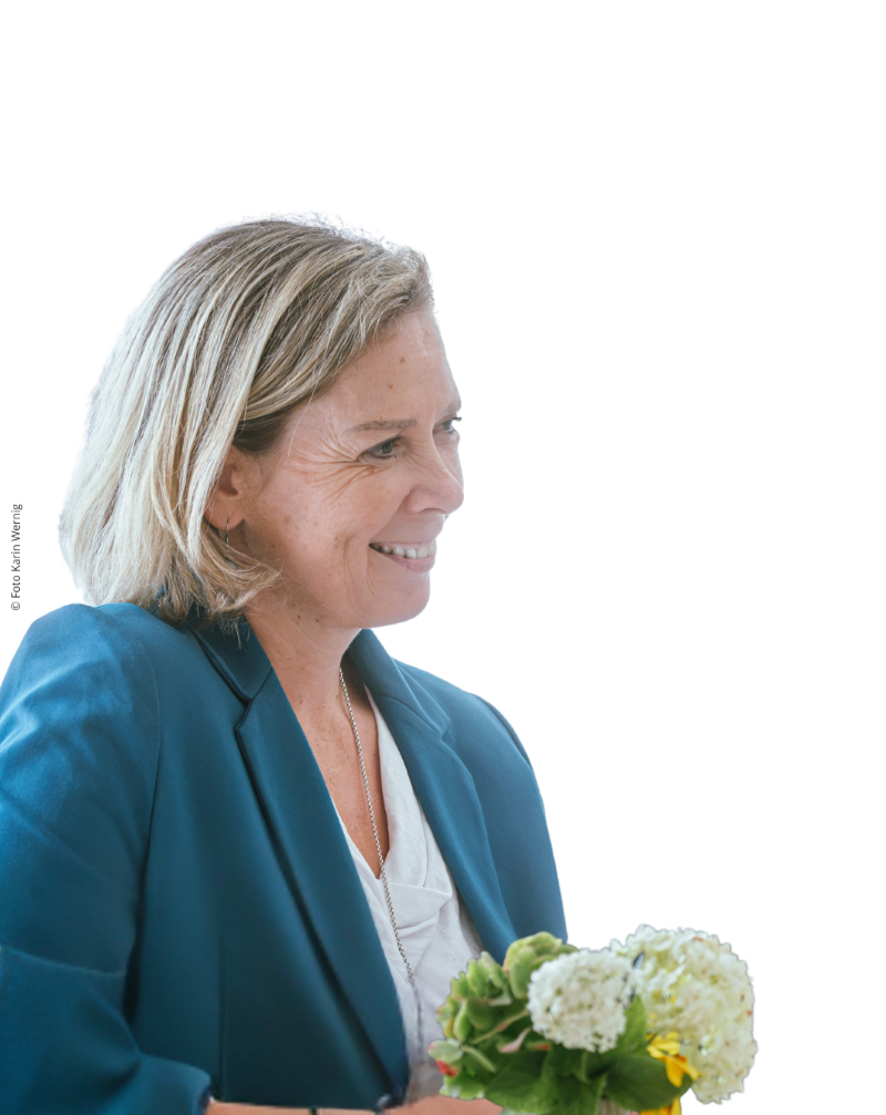 Eine Frau mit blauem Blazer und blonden Haaren im Seitenprofil